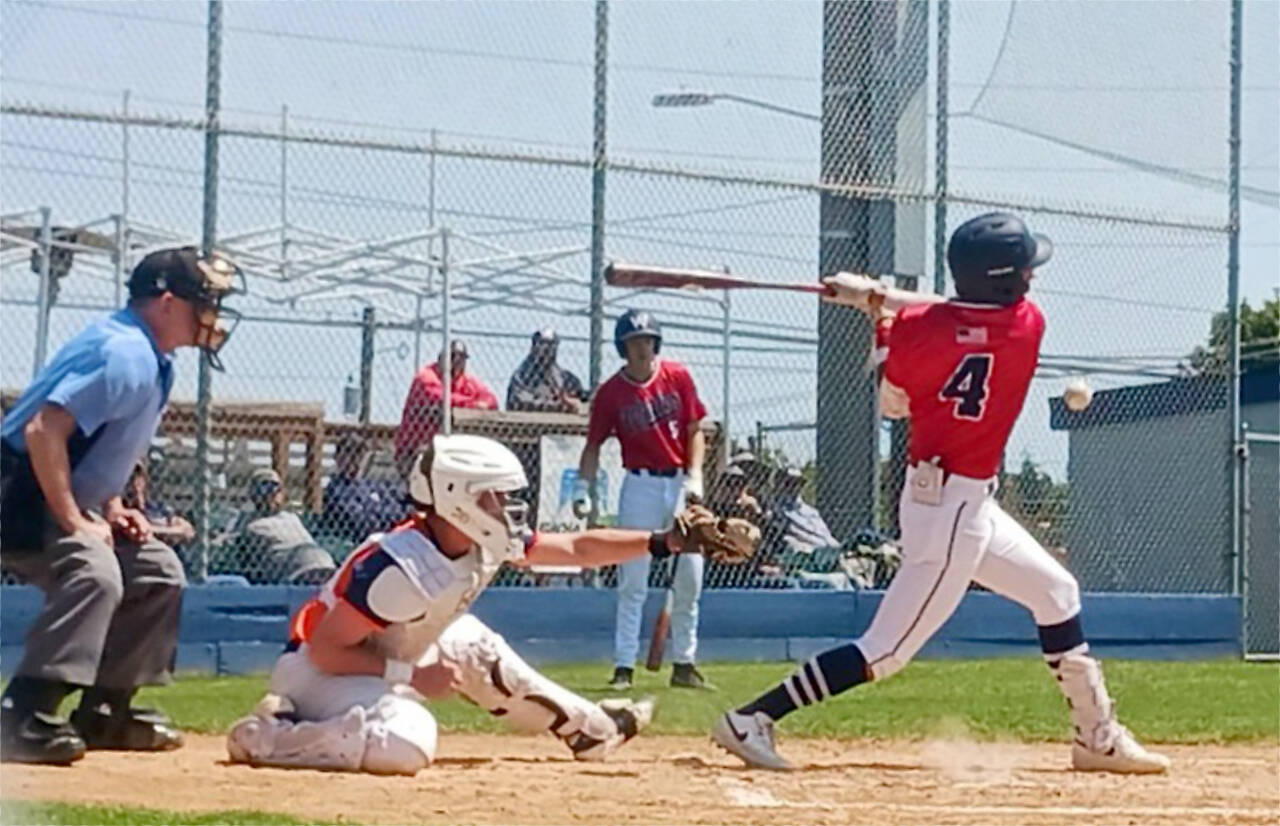 Wilder Senior’s Bryant Laboy hits a chopper against Whatcom Post No. 7 while Landen Olson waits in the on-deck circle. Wilder Senior was able to win the pitchers’ duel with a walk-off hit in the bottom of the seventh by Braydan White. (Pierre LaBossiere/Peninsula Daily News)