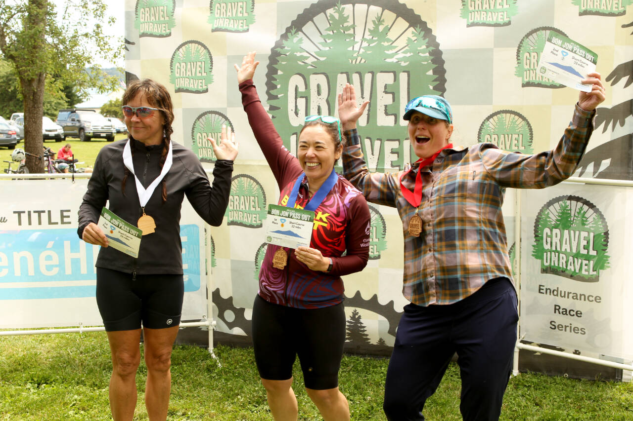 The top three finishers in the women's masters short course race of the Gravel Unravel this weekend celebrate in Quilcene receiving their medals. From left are Jennifer Ritter of Boise, Idaho, third, Emiko Atherton of Seattle, first, and Shaun Baesman of Bainbridge, second. (David Goetze)