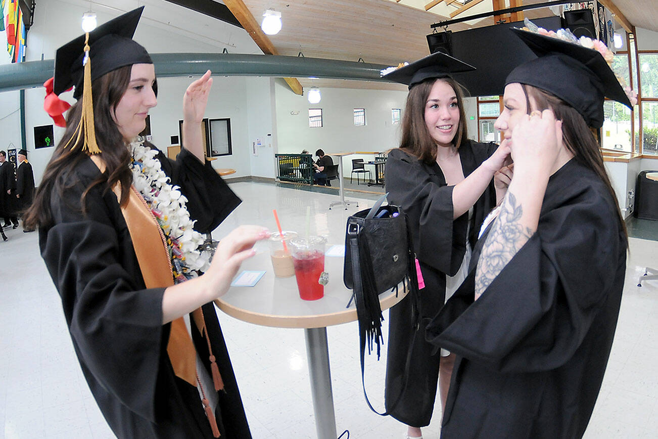 Peninsula College nursing students, from left, Emily Haddock of Lewiston, Idaho, Jordan Hegtvedt of Sequim and Chaela Cashman of Port Angeles adjust each other’s mortar boards in preparation for commencement ceremonies on Saturday on the college’s Port Angeles campus. A total of 328 students were expected to take part in two ceremonies with 530 students eligible for diplomas and certificates for the 2024-25 academic year. (Keith Thorpe/Peninsula Daily News)