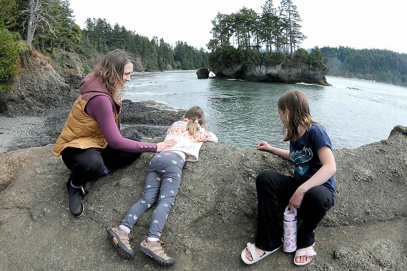 Carissa Guiley of Silverdale, left, along with daughters Mia Guiley, 5, and Evelyn Guiley, 8, peer over a rocky bluff at a sea stack in Crescent Bay on Saturday near Port Crescent. The family was on an outing at Salt Creek County Recreation Area. (Keith Thorpe/Peninsula Daily News)