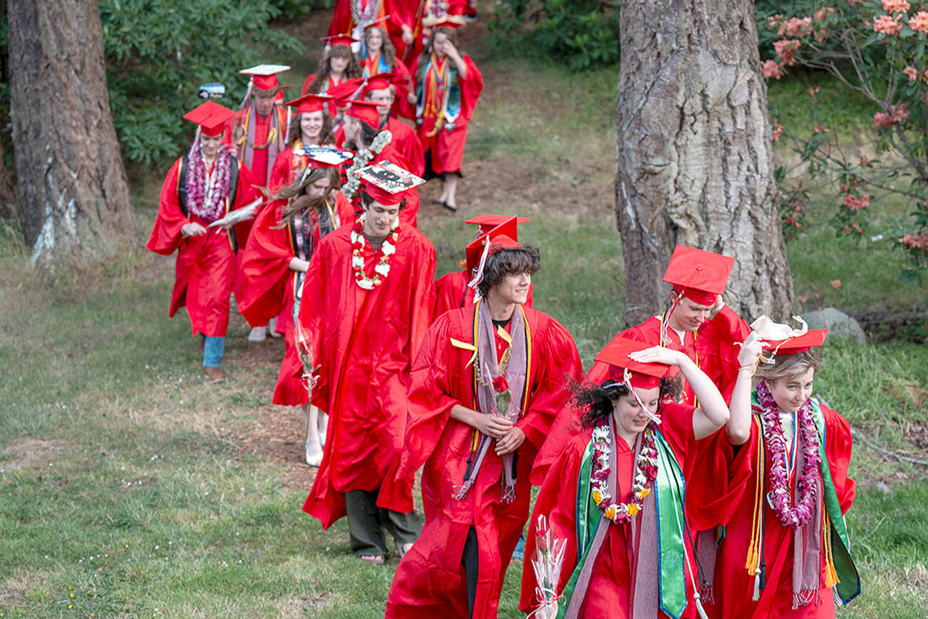 Cadence Harlan and Sophia Petta lead their class of 99 Port Townsend High School graduating seniors through the Rhododendron Garden at Fort Worden State Park on Friday for their graduation ceremony at McCurdy Pavilion. (Steve Mullensky/for Peninsula Daily News)