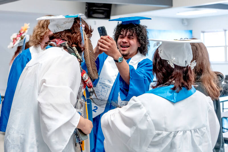 Chimacum High School senior Jesse Daniels takes crazy cell phone photos of his classmates while waiting to march to the gym for his graduation ceremony at Chimacum High on Saturday. (Steve Mullensky/for Peninsula Daily News)