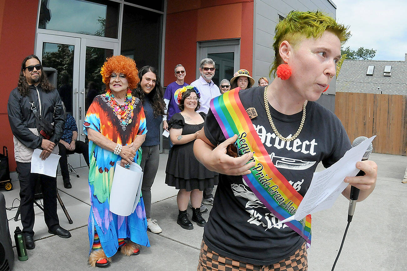Jaiden Dokken, former Clallam County poet laureate and grand marshal of the 2025 Sequim Pride Parade, addresses the audience of Sequim Pride from the steps of Sequim City Hall during Saturday’s Sequim Farmers & Artisans Market. The event, celebrating Pride Month to honor the area’s LGBTQIA2S+ community, featured speeches and a march around downtown Sequim with more than 200 participants followed by a group photo at the city hall plaza. (Keith Thorpe/Peninsula Daily News)