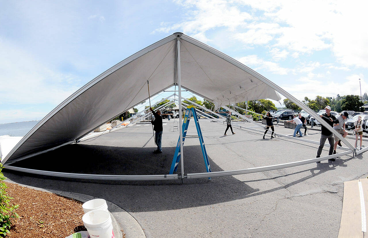 A crew erects an activity tent on Thursday in the parking lot of Port Angeles City Pier in preparation for today’s Independence Day events. For a list of July 4 activities, see www.peninsuladailynews.com/entertainment/fourth-of-july-events-set-on-peninsula/. (KEITH THORPE/PENINSULA DAILY NEWS)