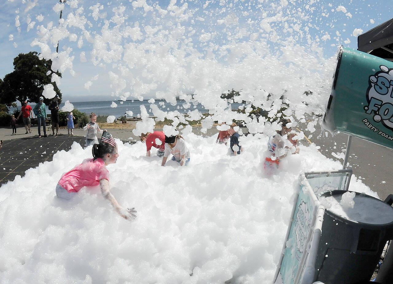 Youngsters cavort in a sea foam as an Independence Day children’s activity at Port Angeles City Pier.
