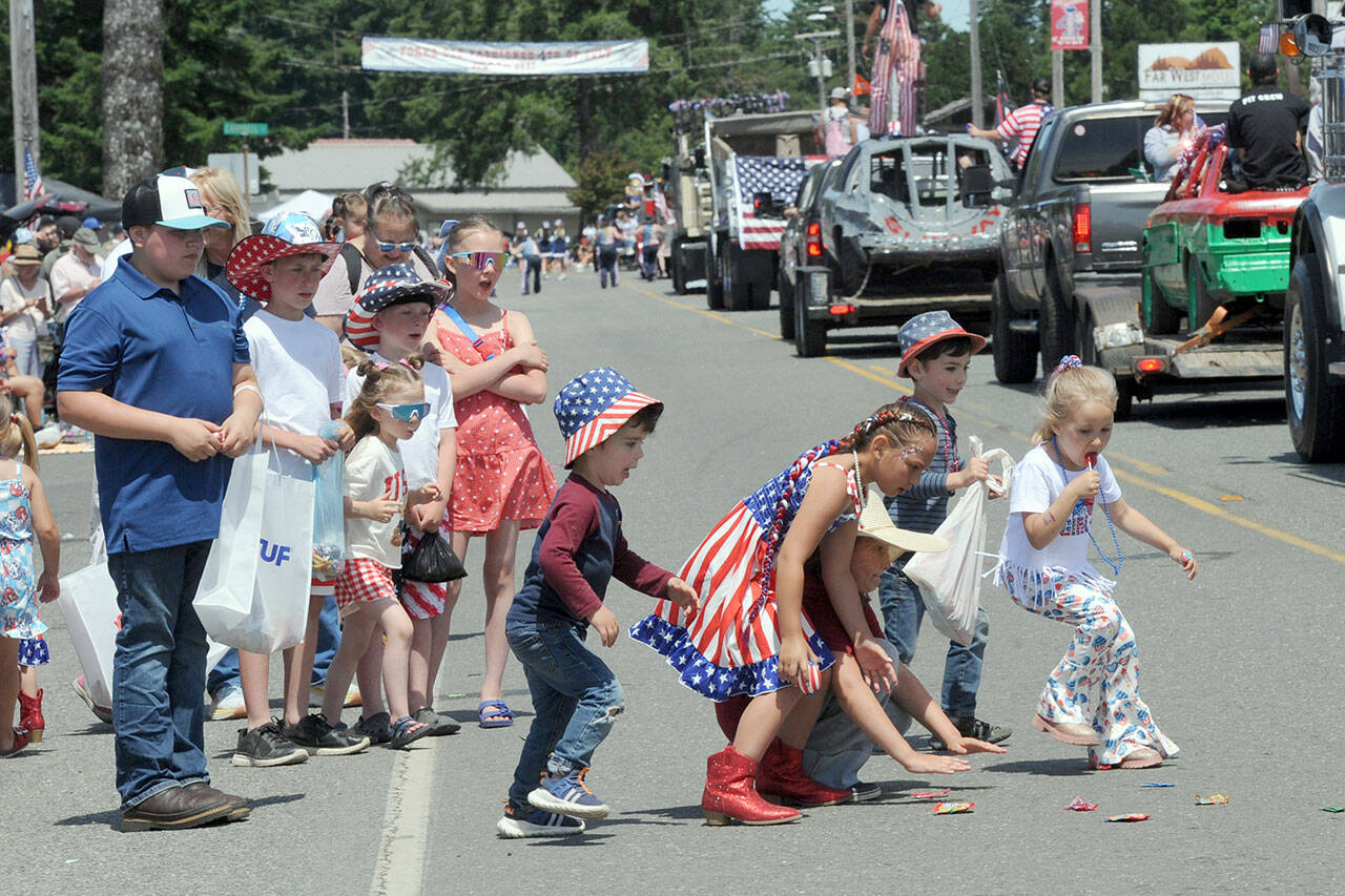 Children pick up candy along the parade route in Forks on Friday during the Forks Old Fashioned 4th of July Parade. (Lonnie Archibald/for Peninsula Daily News)