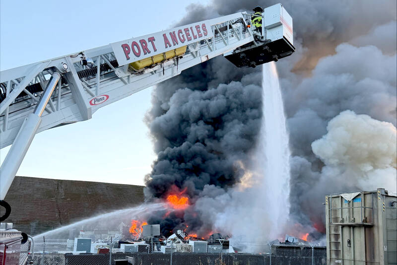 Firefighters work to extinguish a fire at the Port Angeles transfer station on Sunday. (Port Angeles Fire Department)
