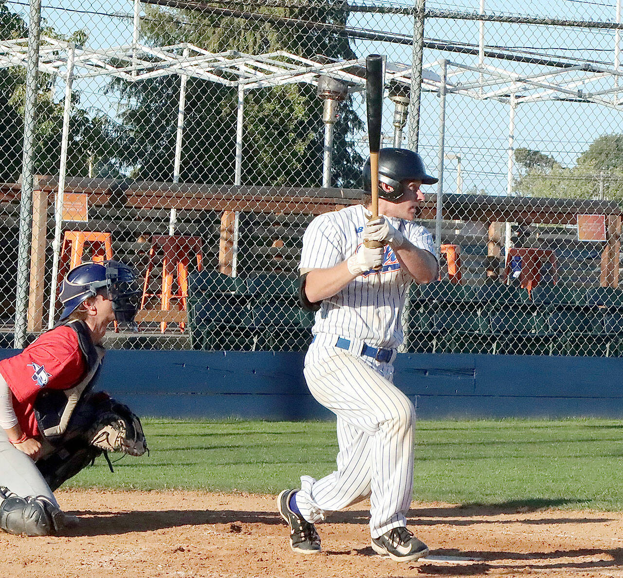 Dave Logan/for Peninsula Daily News Port Angeles’ Tyler Shulman gets a base hit with his turn at the plate in the first inning.