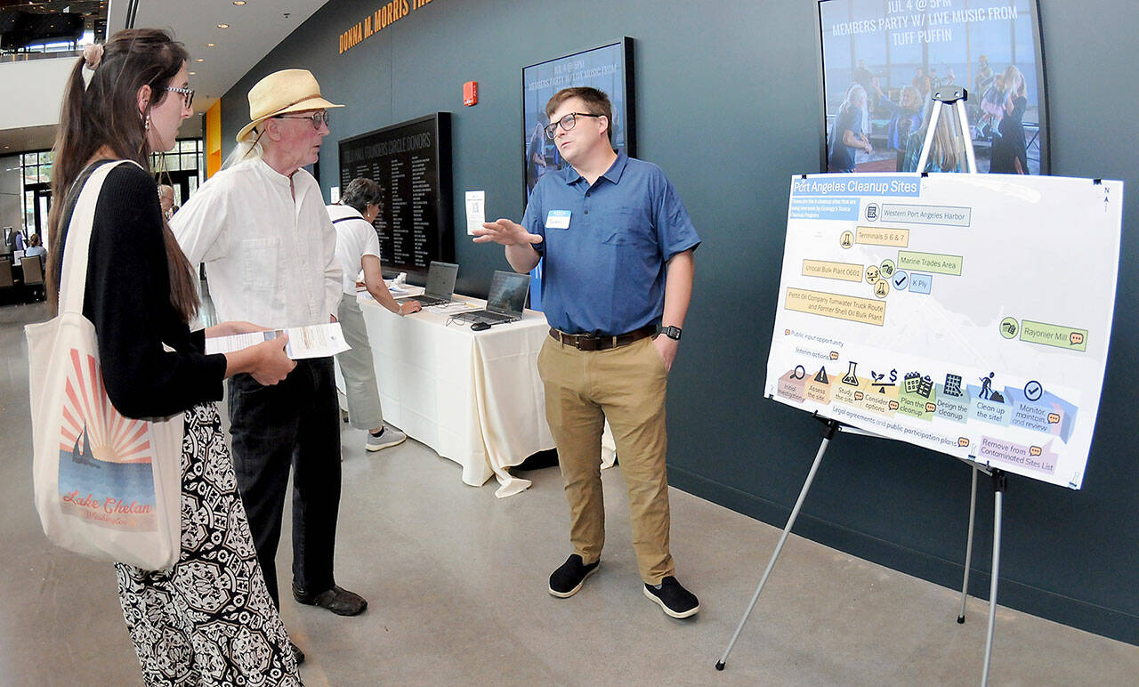 Thomas Praisewater, a site manager with the Washington Dept. of Ecology, right, discusses environmental cleanup sites with Madelynne Jones, left, and Thomas Beatty, both of Port Angeles, during an open house on the status cleanup of the former Rayonier mill site on Tuesday at the Field Arts & Events Hall. (KEITH THORPE/PENINSULA DAILY NEWS)