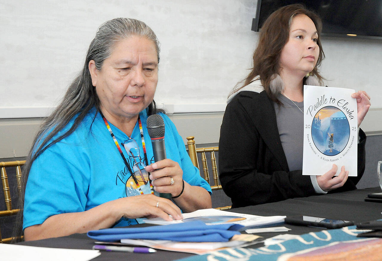 Lower Elwha Klallm Tribal Chairwoman Frances Charles, left, speaks about the Paddle to Elwha 2025 canoe journey as Carmen Watson-Charles, the tribe’s cultural manager, holds an informational pamphlet during a presentation to the Port Angeles Chamber of Commerce on Wednesday. (Keith Thorpe/Peninsula Daily News)