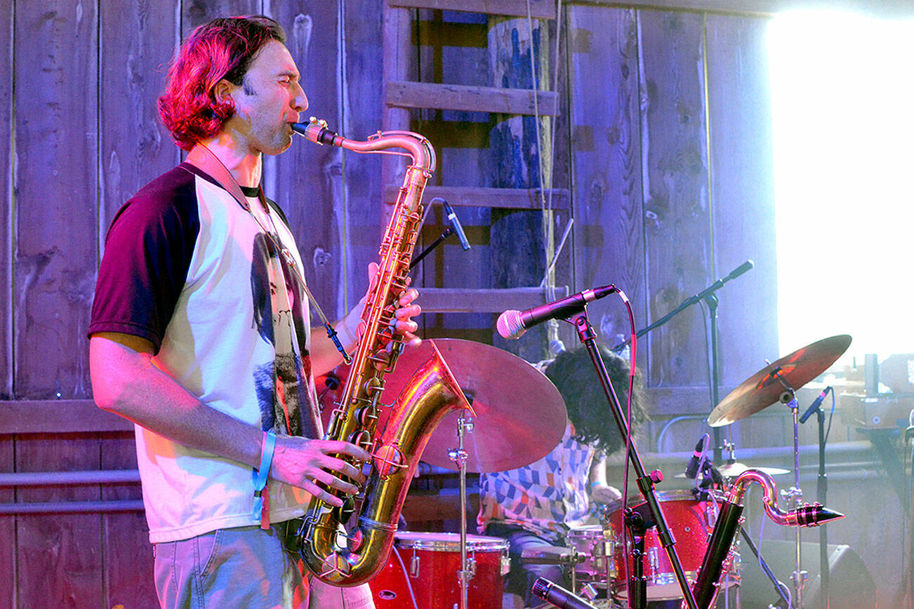 Levi Gillis, the saxophonist for The Sky Is A Suitcase, plays during a concert on July 5. (Elijah Sussman/Peninsula Daily News)