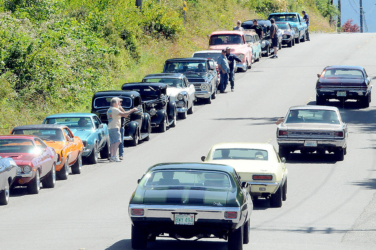 Vintage cars line up along Golf Course Road waiting entry into the 29th annual Ruddell Cruise-in car show on Friday at Ruddell Auto in Port Angeles. (Keith Thorpe/Peninsula Daily News)