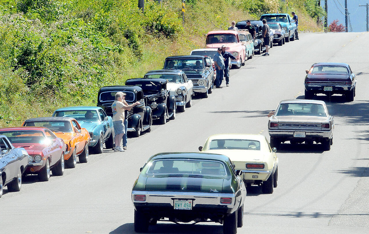 Vintage cars line up along Golf Course Road waiting entry into the 29th annual Ruddell Cruise-in car show on Friday at Ruddell Auto in Port Angeles. (Keith Thorpe/Peninsula Daily News)