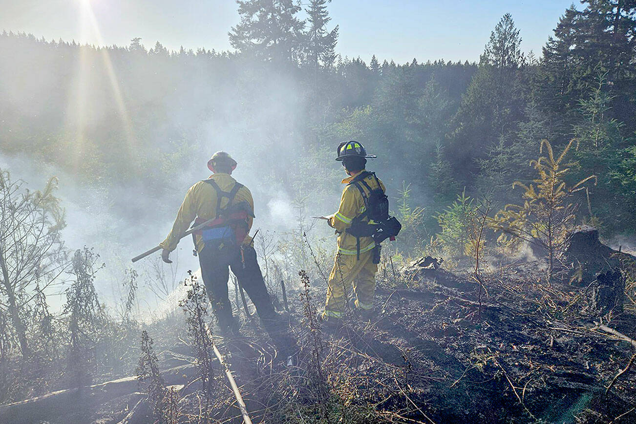 Firefighters from Clallam 2 Fire-Rescue oversee a brush fire Wednesday in the area of Baker Farm Road. (Clallam 2 Fire-Rescue)