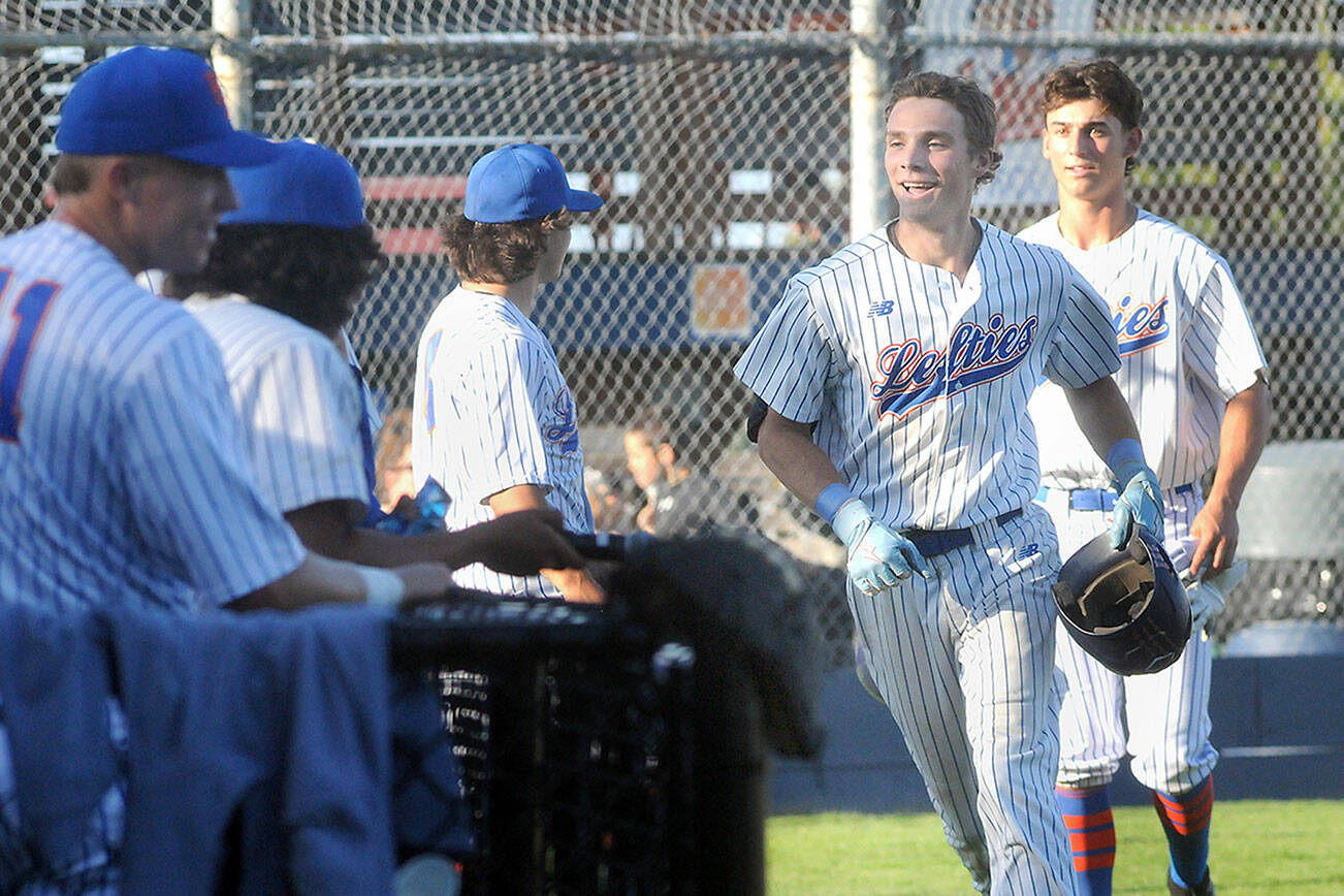KEITH THORPE/PENINSULA DAILY NEWS
Lefties outfielder Garrett Cooper, second from right, is greeted by his teammates after rounding the bases on a home run against the Redmond Dudes on Thursday evening at Port Angeles Civic Field.