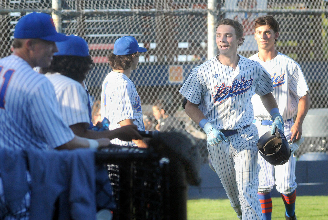 KEITH THORPE/PENINSULA DAILY NEWS Lefties outfielder Garrett Cooper, second from right, is greeted by his teammates after rounding the bases on a home run against the Redmond Dudes on Thursday evening at Port Angeles Civic Field.