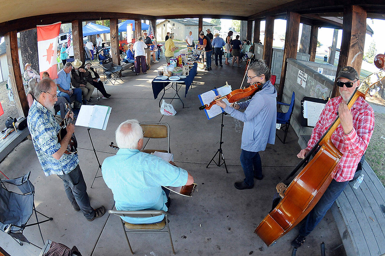 Members of the musical group Soupbones, from left, Ed Schmid of Port Angeles, Ron Munro of Sequim, Carly List of Port Angeles and Hugh Starks of Sequim, perform at a Good Trouble community gathering and picnic on Thursday at Erickson Playfield in Port Angeles. Organizers of the event, one of numerous gatherings across the United States, decided to forego conventional politics while commemorating the life of civil rights activist John Lewis. (Keith Thorpe/Peninsula Daily News)