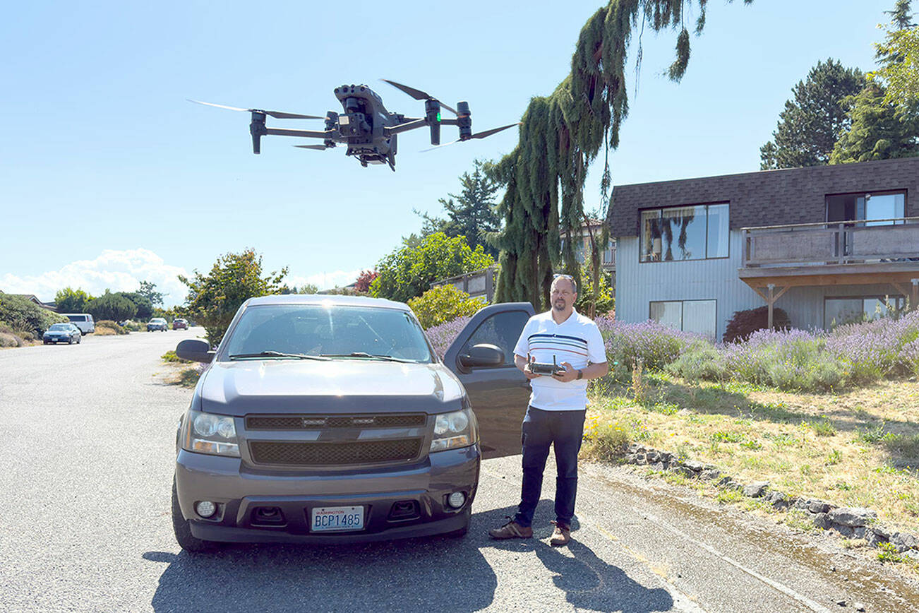 Det. Sgt. Jason Greenspane of the Port Townsend Police Department sets a drone in a hover mode after he brought it back from a test flight. Greenspane wanted to determine how far he could get a clear signal. On this flight, he flew the drone over the boat haven and all the way to Point Hudson Marina and back, a distance of about 2 1/2 miles. The drone is equipped with a camera that zooms, pans and swivels 360 degrees and can shoot still images as well as video. The police use the drone for search and rescue operations and other life-saving missions. (Steve Mullensky/for Peninsula Daily News)
