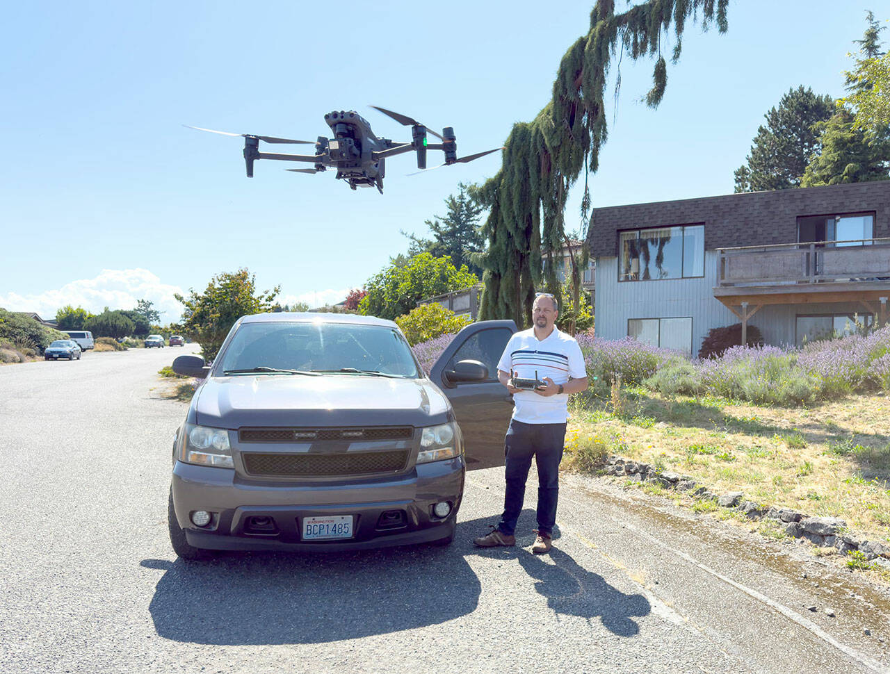 Det. Sgt. Jason Greenspane of the Port Townsend Police Department sets a drone in a hover mode after he brought it back from a test flight. Greenspane wanted to determine how far he could get a clear signal. On this flight, he flew the drone over the boat haven and all the way to Point Hudson Marina and back, a distance of about 2 1/2 miles. The drone is equipped with a camera that zooms, pans and swivels 360 degrees and can shoot still images as well as video. The police use the drone for search and rescue operations and other life-saving missions. (Steve Mullensky/for Peninsula Daily News)