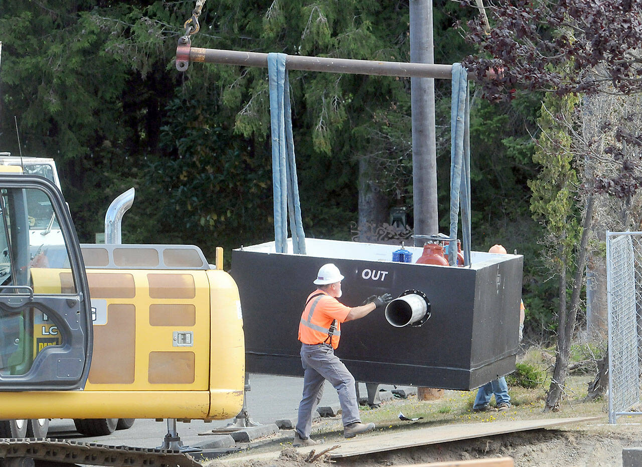 Workers maneuver a newly-delivered vault containing a water valve at the site of a valve replacement project on Thursday at the Jones Street Reservoir in Port Angeles. (KEITH THORPE/PENINSULA DAILY NEWS)