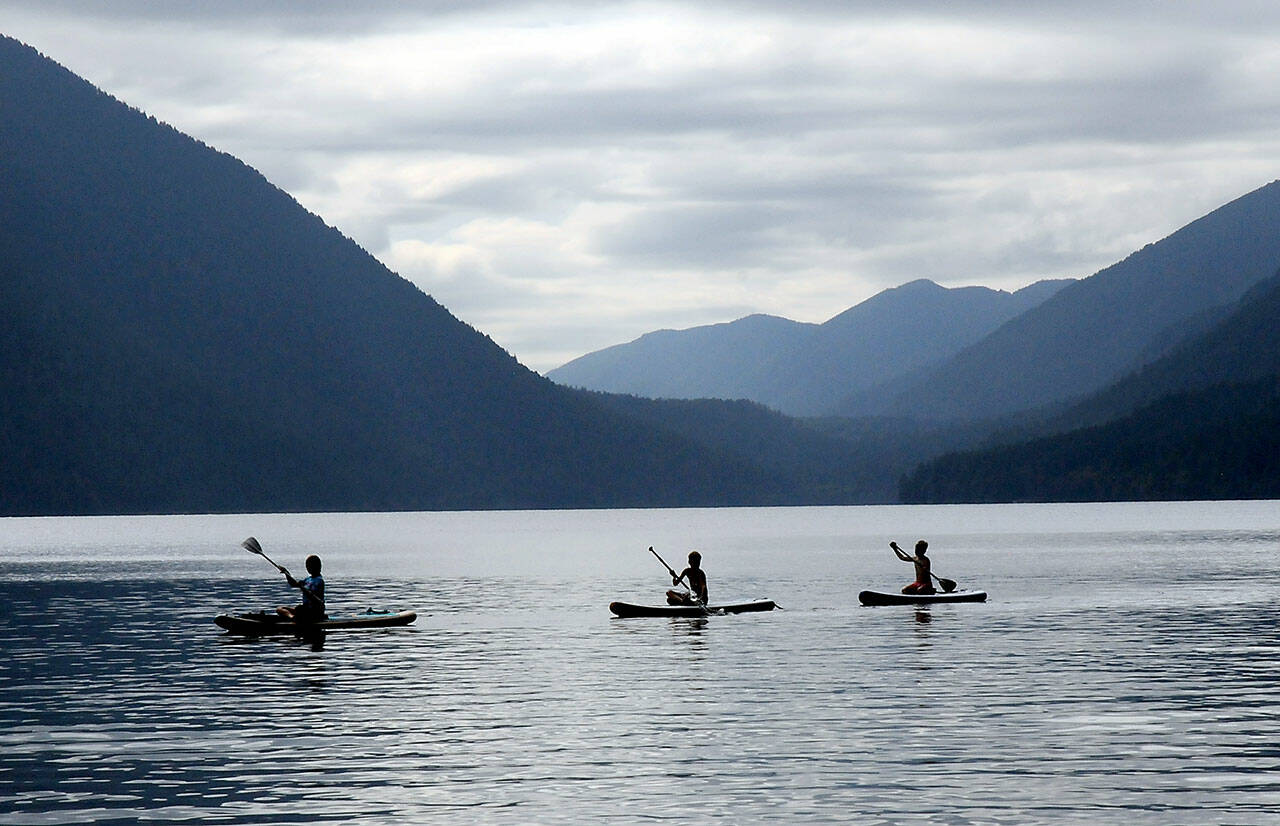 A trio of paddeboarders make their way across the waters of Lake Crescent off of Barnes Point on Sunday in Olympic National Park. Calm winds made for an ideal day for watercraft on the popular lake west of Port Angeles. (Keith Thorpe/Peninsula Daily News)
