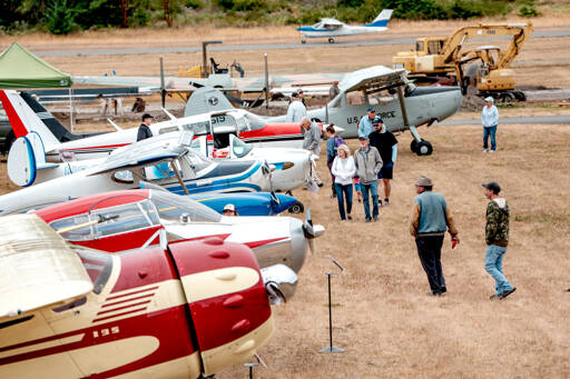 Spectators roam the grounds of Jefferson County International Airport looking over some of the historic airplanes on display during the second annual Jefferson County Airport Day on Saturday. (Steve Mullensky/for Peninsula Daily News)