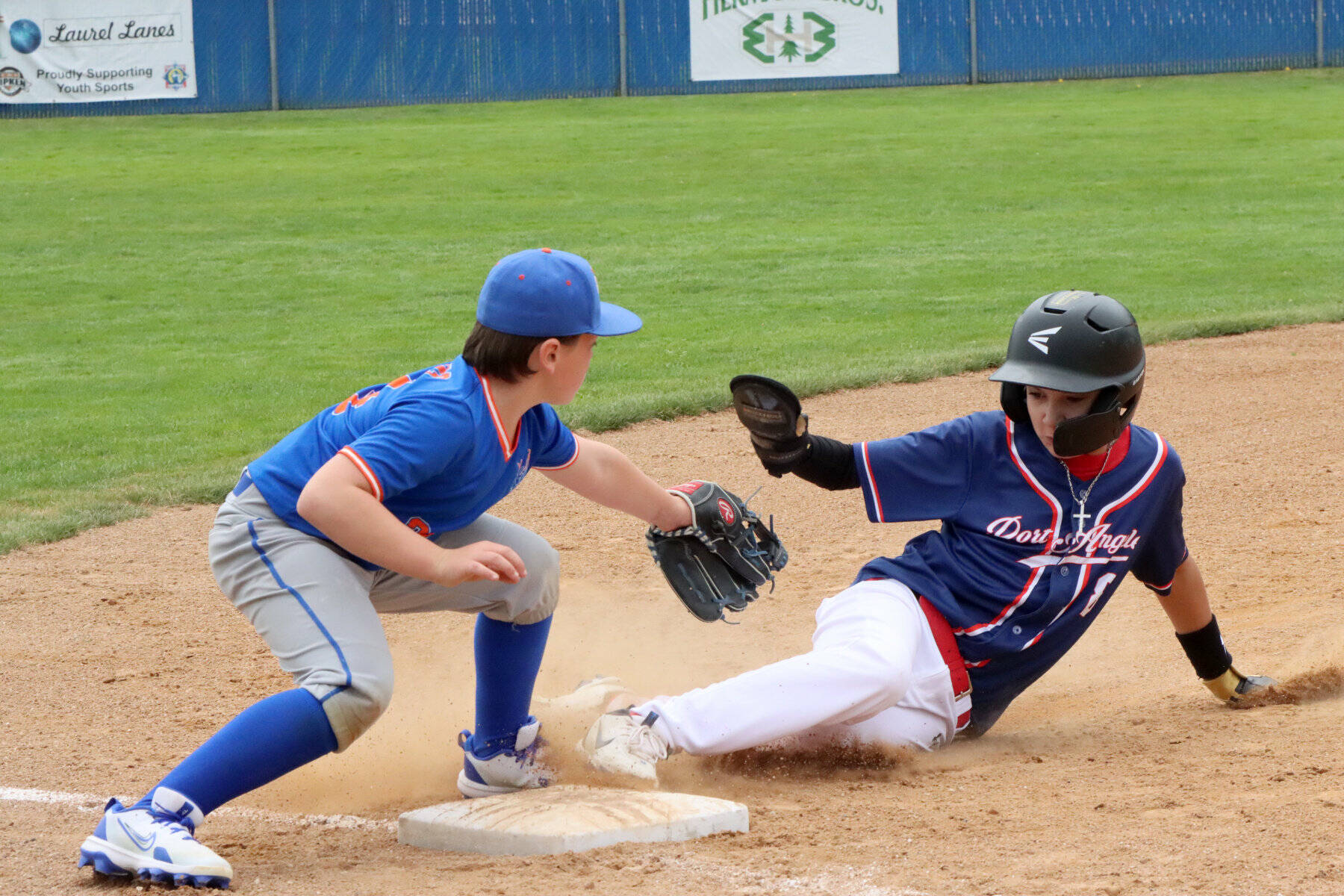 Carson Stovall of the Port Angeles 11U baseball team slides safely into third base, beating the tag of Dax Higgins of the Kingston Kings this weekend at Lincoln Park. The Port Angeles team went on to win its opening game of the Dick Brown Memorial Tournament 15-6. Thirteen teams from ages 8 to 11 competed in the two-day tournament. (Dave Logan/For Peninsula Daily News)