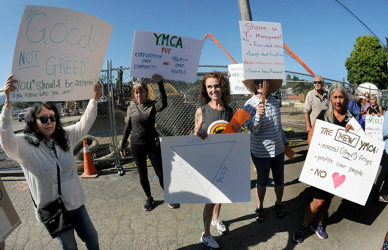 Former Olympic Peninsula YMCA employee Mikki Hughes, center, stands on Wednesday in front of the Port Angeles YMCA with friends and co-workers who protested Hughes’ dismissal from her longtime duties as fitness instructor and fitness coordinator. (Keith Thorpe/Peninsula Daily News)