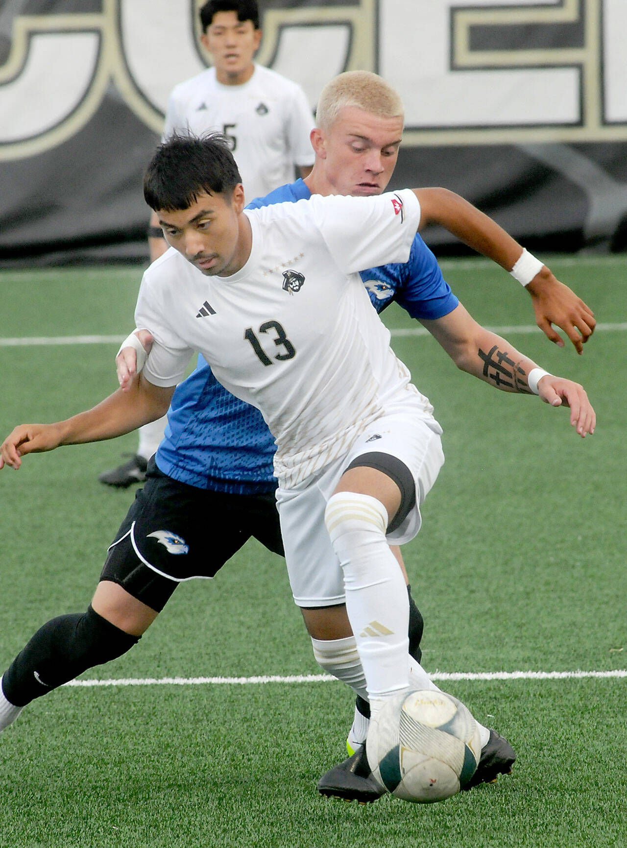 KEITH THORPE/PENINSULA DAILY NEWS Peninsula’s Ezrah Ochoa, front, dribbles past Rogue’s Mason Klipfel during Friday’s match at Wally Sigmar Field. In the background is Ochoa’s teammate Rei Sato.