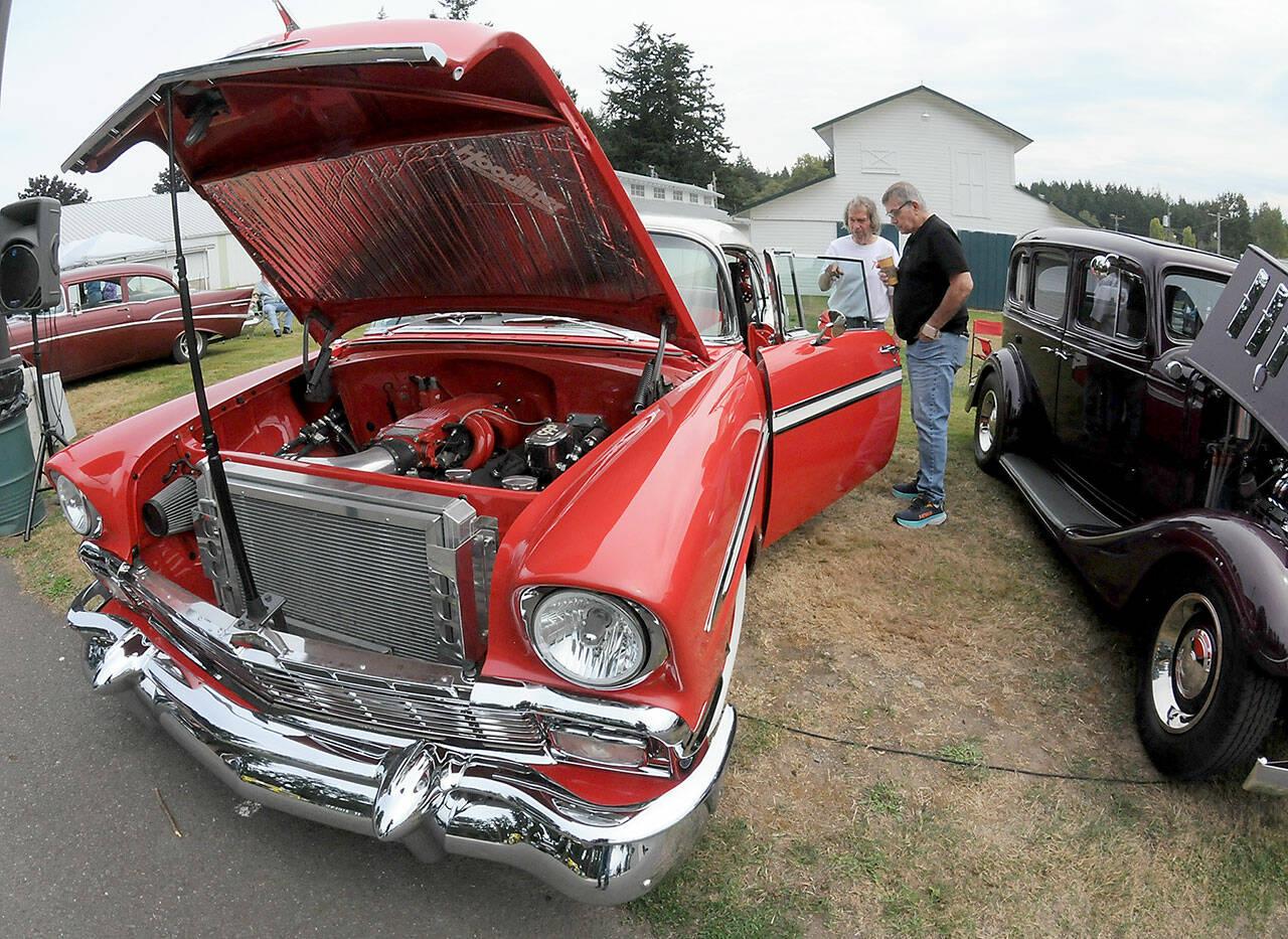 Vintage car owner Alfred Dese of Port Angeles, left, describes automotive details to Bob York of Port Angeles as they examine Dese’s 1956 Chevrolet Bel Air during Saturday’s fourth annual John Burkheimer Memorial Car Show & Chili Cook-Off at the Clallam County Fairgrounds. Dozens of antique and vintage automobiles were featured at the event, which also included the cookoff as well as other food and music as a benefit for the Kiwanis Club of Port Angeles, which hosted the show. (Keith Thorpe/Peninsula Daily News)