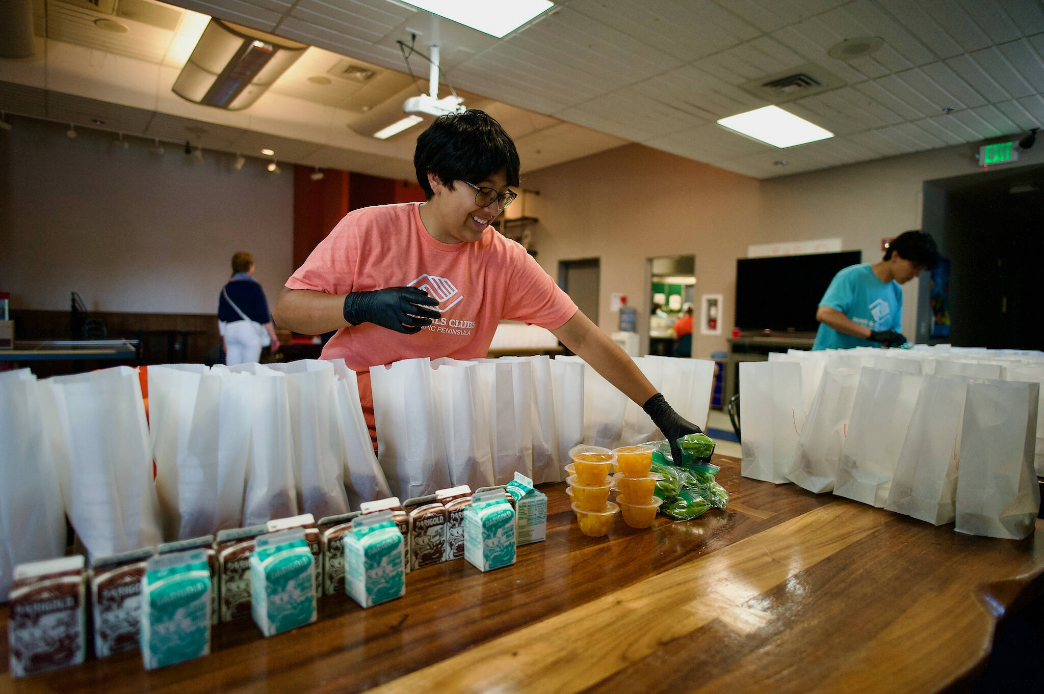 Jacques Star/Olympic Peninsula News Group
Teen workers and Boys & Girls Club staff make sure lunch sacks are filled with nutritious items.