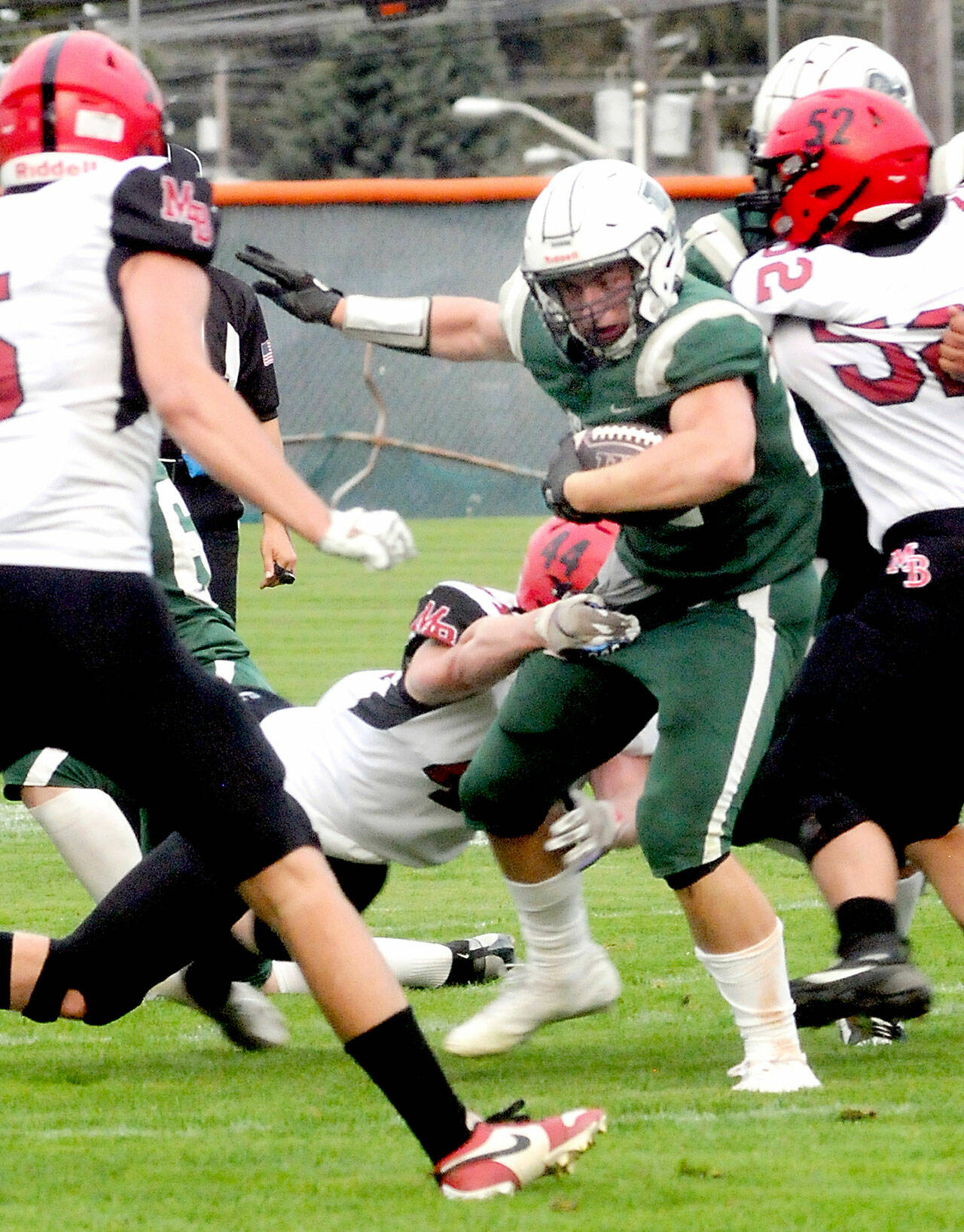 KEITH THORPE/PENINSULA DAILY NEWS Port Angeles running back Dylan Mann, center, tries to evade the tackle by Mount Baker’s Kamden Moa during Friday evening’s game at Port Angeles Civic FIeld.