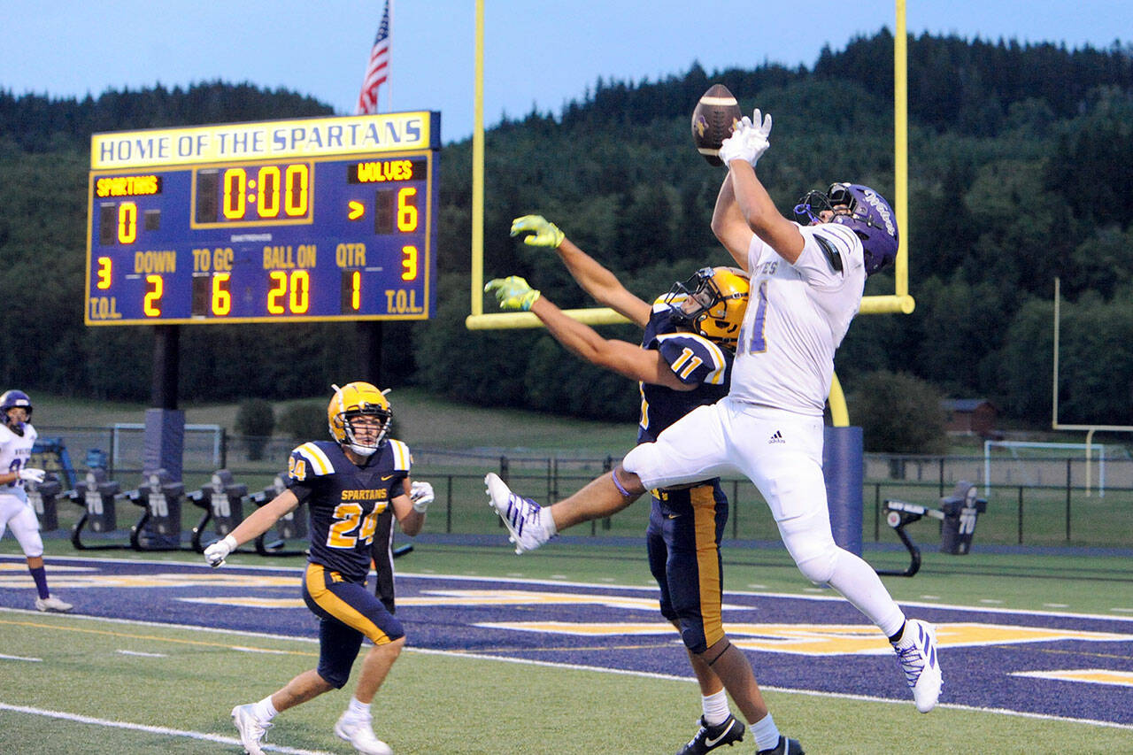This Sequim pass to Liam Wiker (11) was deflected by Forks’ Cash Barajas (11) then intercepted by Forks’ Kingston Steffen (24). The Wolves held on in the closing moments for an 18-14 victory. (Lonnie Archibald/for Peninsula Daily News)