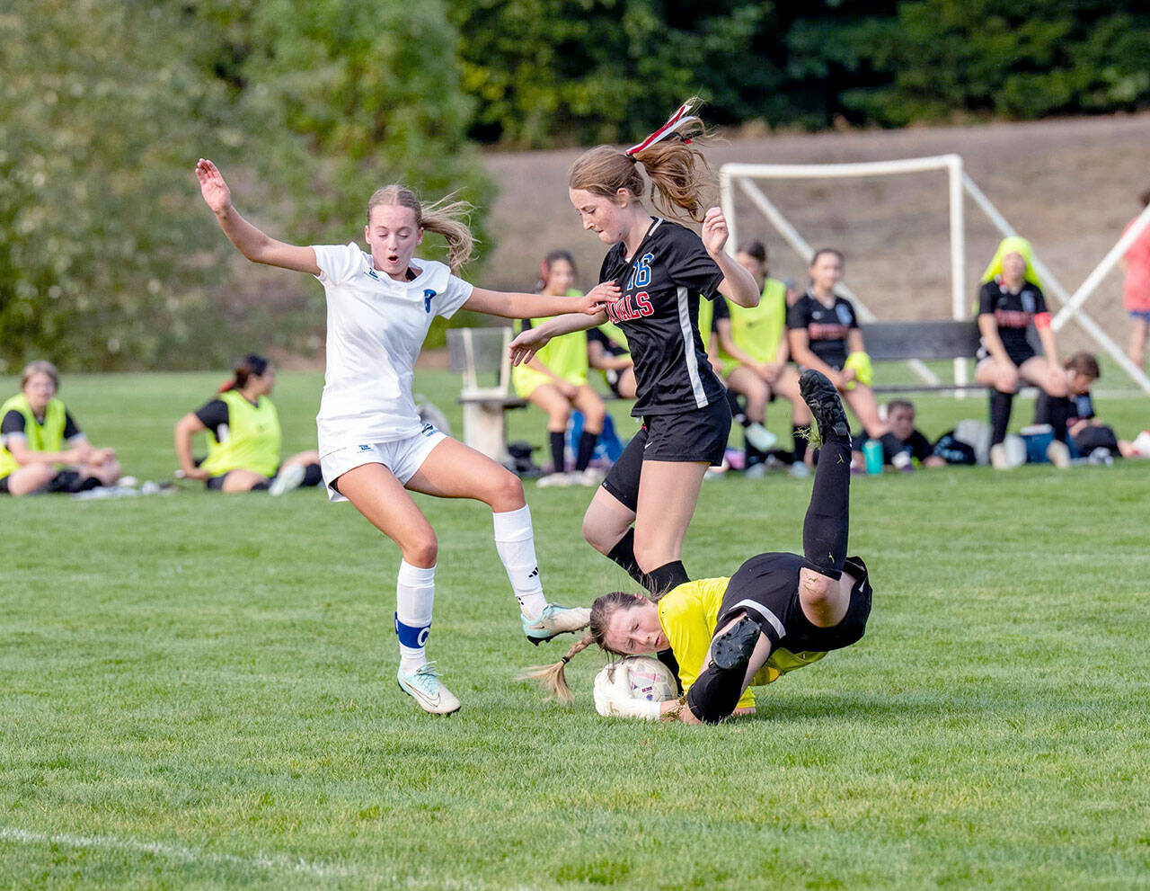 East Jefferson’s goalkeeper Lila Morgan makes a diving save off the foot of Bellevue Christian’s Emily Eggers as the Rivals’ Fern French (16) is in on the play during a Nisqually League game played on Tuesday at H.J. Carroll Park in Port Hadlock. (Steve Mullensky/for Peninsula Daily News)