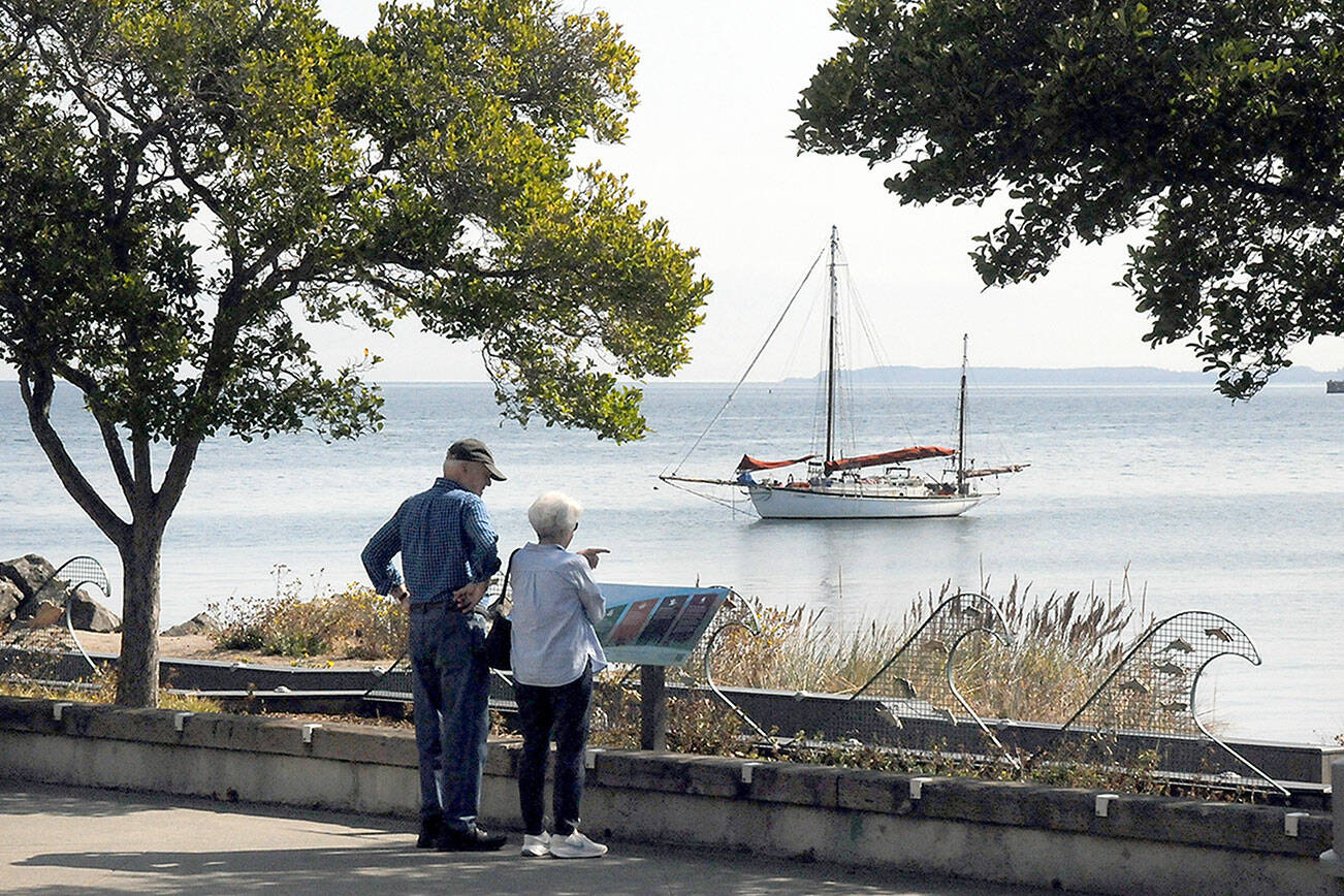 Wayne and Carolyn Stewart of Portland, Ore., look over Port Angeles Harbor as the sailboat Cytherea, homeported in Tomales Bay, Calif., sits at anchor off Port Angeles City Pier. The Stewarts were visiting the North Olympic Peninsula with plans for a journey to Victoria. (Keith Thorpe/Peninsula Daily News)