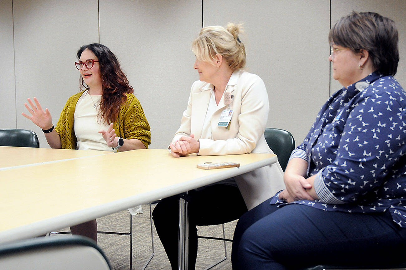 Schelle Fitzpatrick, left, explains her experience in Olympic Medical Center’s nursing residency program as the hospital’s Chief Nursing Officer Vickie Swanson and Director of Education and Organizational Professional Development look on. Since 2017, 132 nurse graduates have gone through the program, which provides clinical experience, mentoring and support. (Keith Thorpe/Peninsula Daily News)