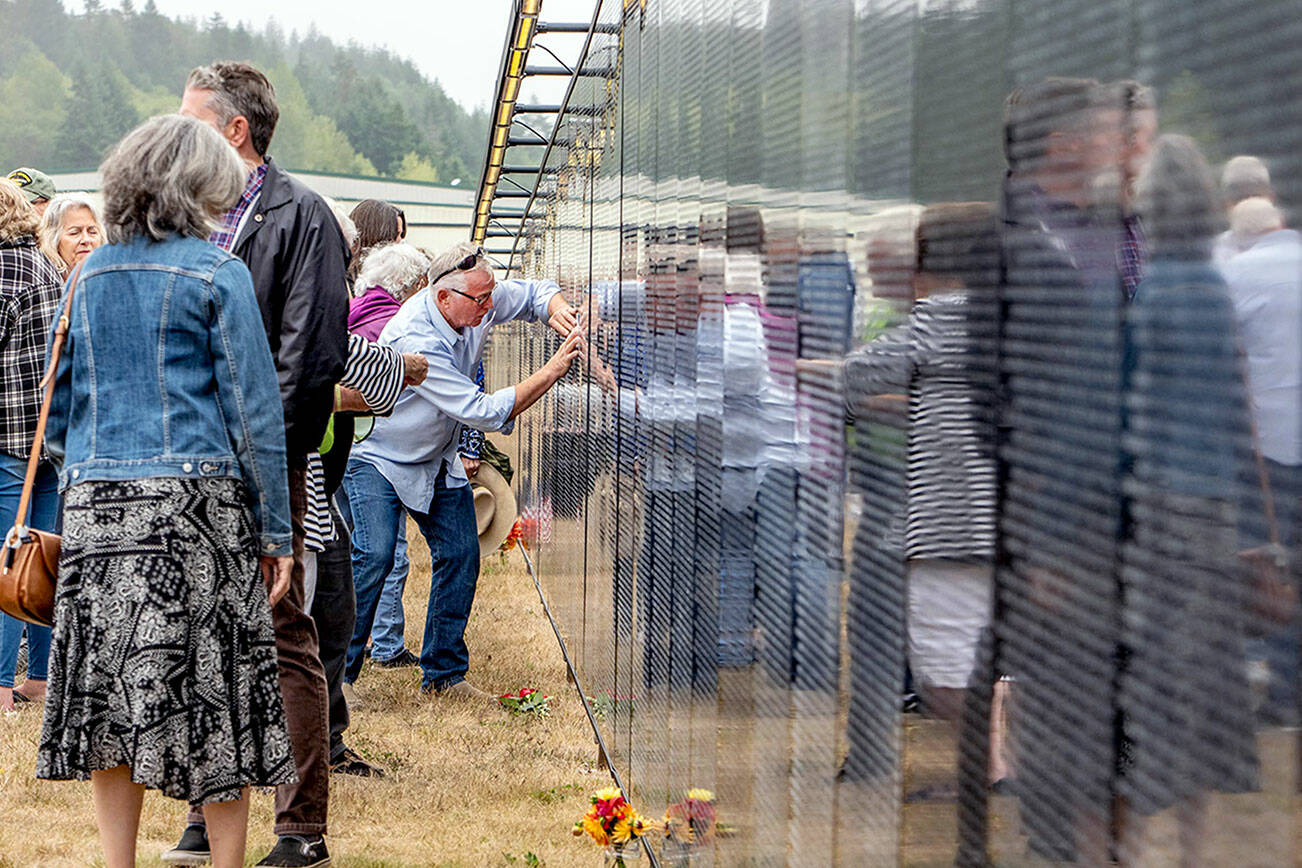 Frank Arey of Port Hadlock rubs his uncle Stephen R Lopeman’s name that is etched in the three-quarter scale Vietnam Veterans Memorial on display at Jefferson County International Airport until 2 p.m. Sunday. Lopeman, a 1968 Port Townsend High School graduate, died in Vietnam in 1969. (Steve Mullensky/for Peninsula Daily News)