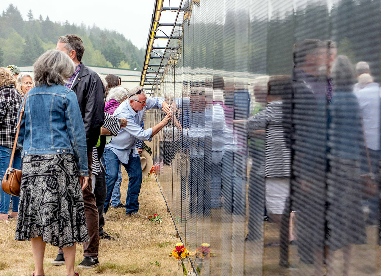 Frank Arey of Port Hadlock rubs his uncle Stephen R Lopeman’s name that is etched in the three-quarter scale Vietnam Veterans Memorial on display at Jefferson County International Airport until 2 p.m. Sunday. Lopeman, a 1968 Port Townsend High School graduate, died in Vietnam in 1969. (Steve Mullensky/for Peninsula Daily News)