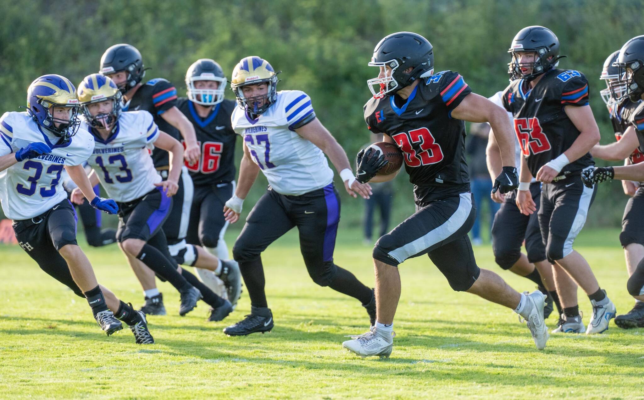 East Jefferson’s Luke O’Hara runs a gauntlet of Friday Harbor defenders during a Friday night non-league game played against Friday Harbor in Port Townsend’s Memorial Field. East Jefferson won 14-13. (Steve Mullensky/for Peninsula Daily News)