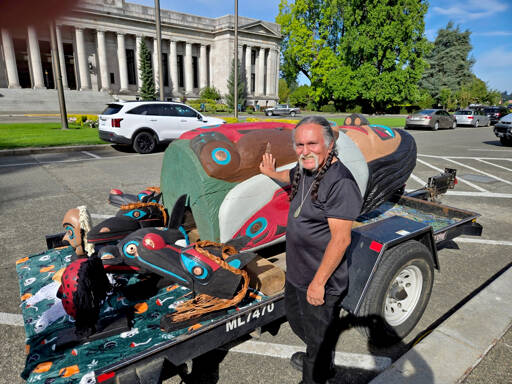 Lummi master carver Jewell James stands with the totem pole at a rally in Olympia. (Se’Si’Le)
