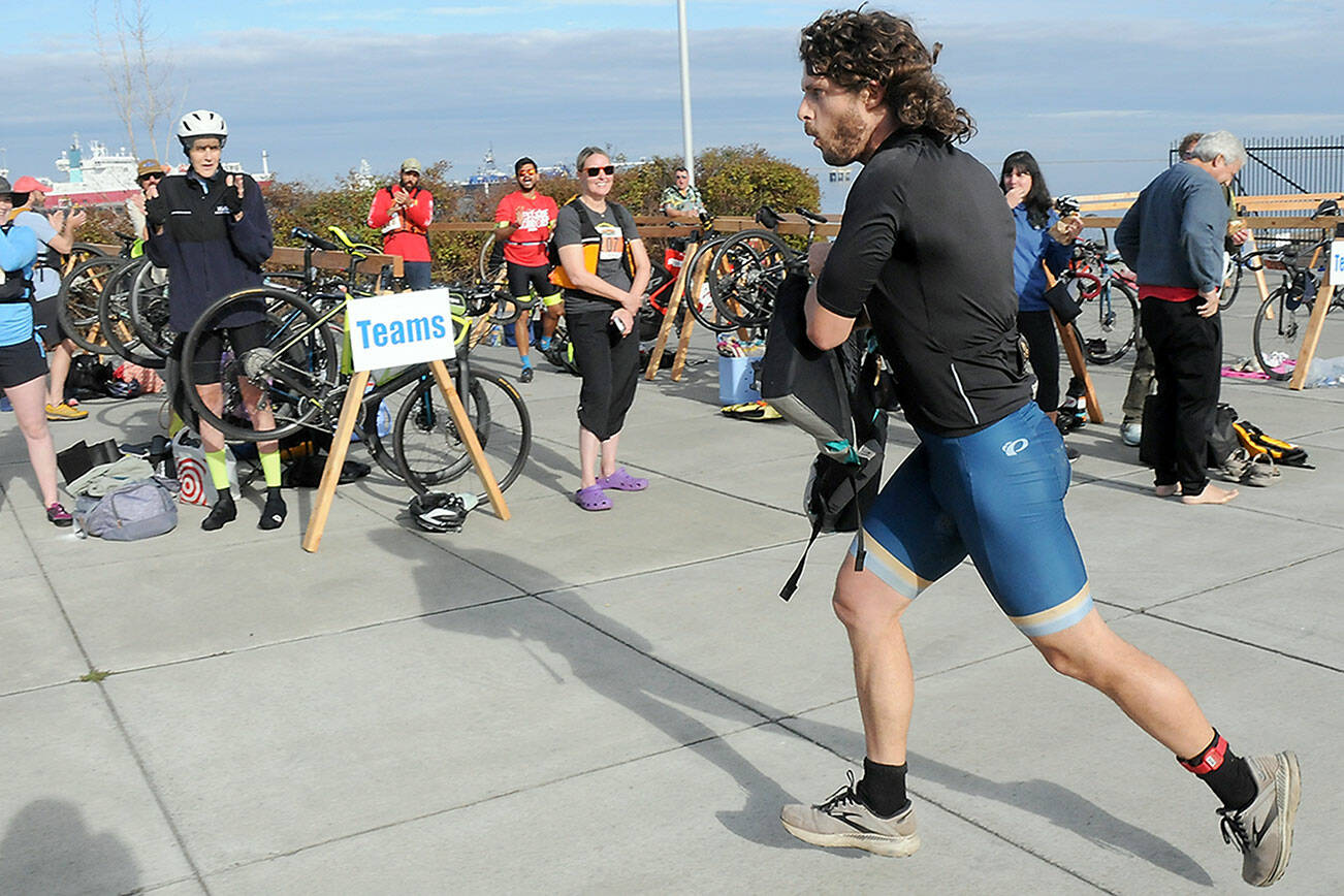 KEITH THORPE/PENINSULA DAILY NEWS
Big Hurt iron man competitor Joey Gish of Sequim races through the transfer zone on the way to his kayak after finishing the mountain bike leg of the race in first place on Saturday at Pebble Beach Park in Port Angeles. Gish finished second in the iron division in the 2024 Big Hurt