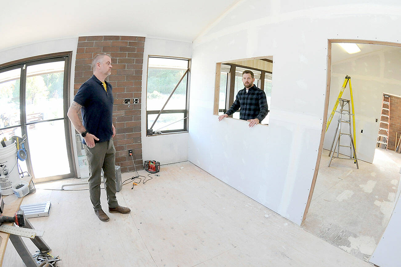 Trevor Sly, operations manager of Olympic Hiking Co., left, and Tommy Farris, company owner and general manager, discuss relocating their business from The Wharf on the Port Angeles Waterfront to a new office on West Marine Drive. (Keith Thorpe/Peninsula Daily News)