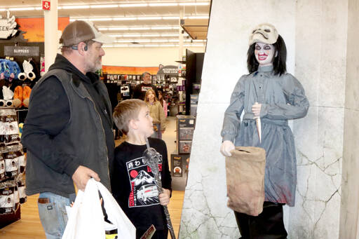 Leif Bishop, 9, and his father Jason Bishop are taken aback by a scary prop at Spirit Halloween’s entrance, which suddenly pulls up its mask to a scary sound. The seasonal store has opened at 1940 E. First St. in Port Angeles Plaza in the former Big Lots location. Spirit Halloween has been in Sequim for the past four years, but it migrated to Port Angeles this year. The chain store has more than 1,400 locations across North America this time of year. It sells costumes, decorations, props and accessories during the Halloween season. Store hours are from 10 a.m. to 10 p.m. every day through Halloween. It closes at 9 p.m. on Sundays. (Dave Logan/for Peninsula Daily News)