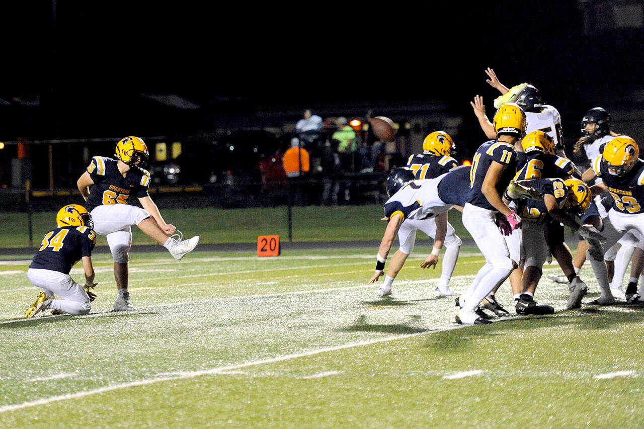 Spartan Tannon Gaydeski holds for kicker Mario Reyes who had a great night kicking extra points and a field goal for Forks in their 37 to 33 win over the Ilwaco Fishermen at Spartan Stadium Friday night. (Lonnie Archibald/Peninsula Daily News)