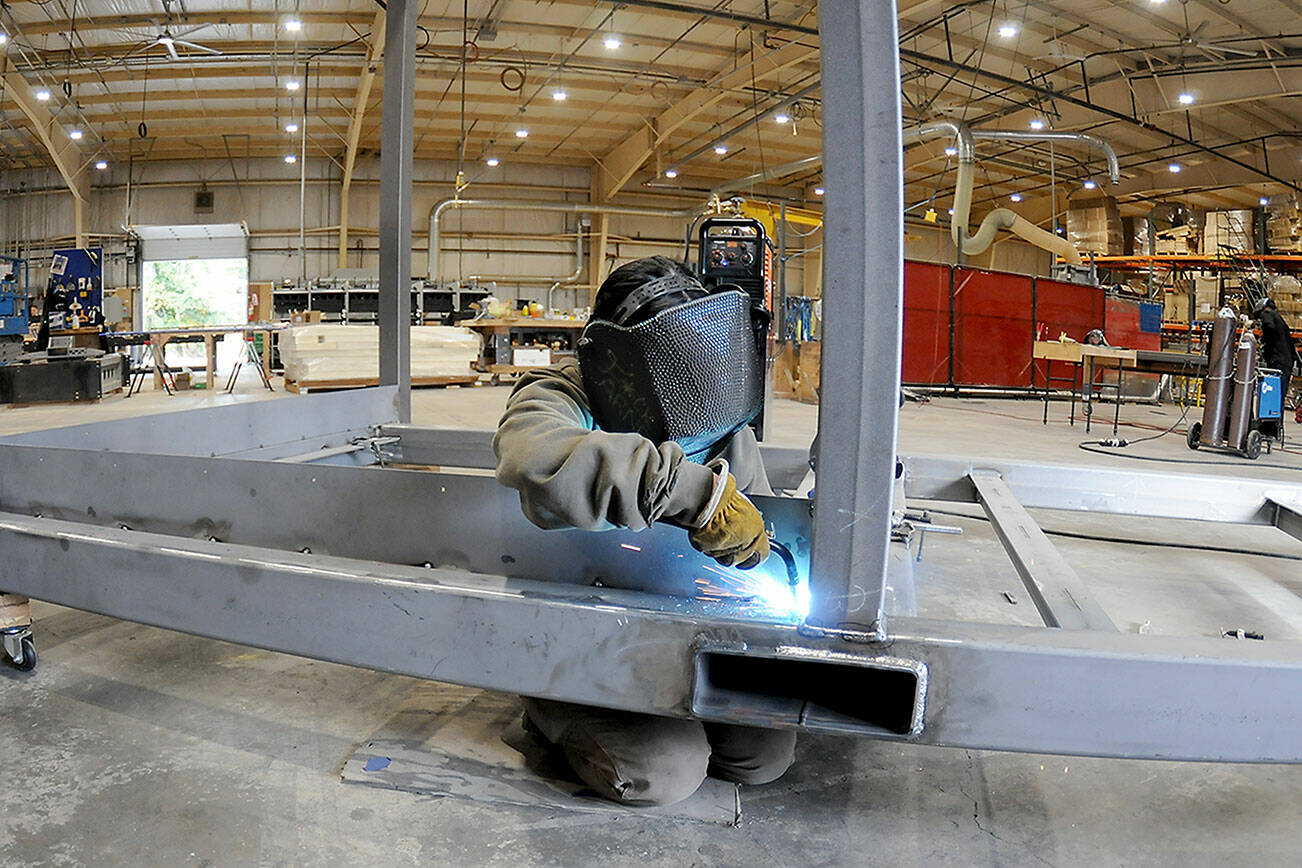 Hailey Robinson welds a steel frame on a component of a temporary military billet being constructed at Composite Recycling Technology Center's Port Angeles facility. (Keith Thorpe/Peninsula Daily News)