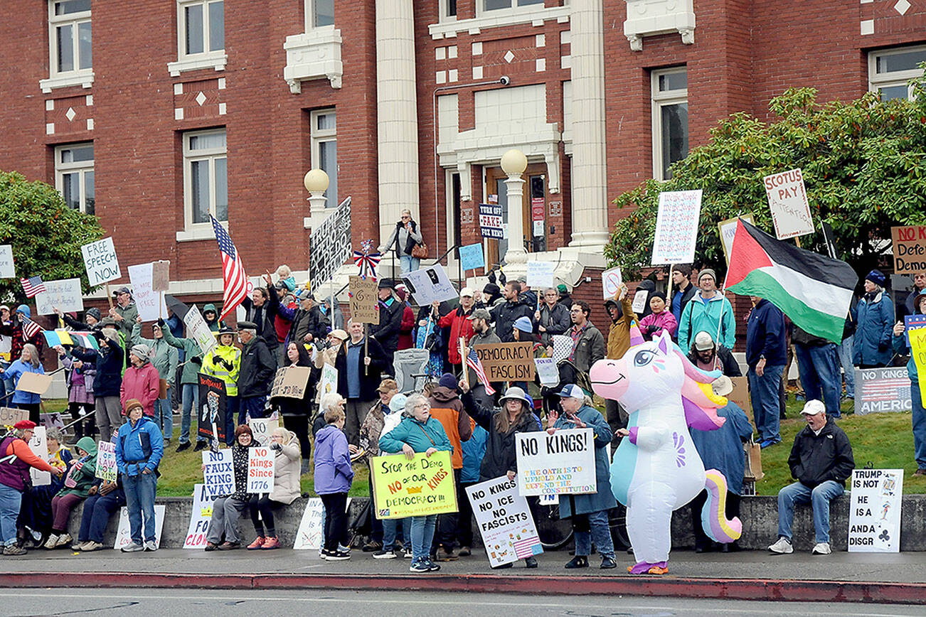 A crowd gathers on the lawn of the Clallam County Courthouse on Saturday for one of two “No Kings” rallies in Port Angeles protesting the policies of President Donald Trump and his administration. Several hundred people attended the courthouse demonstration with about a thousand at a concurrent rally at the intersection of First and Front streets on the east side of the city. (Keith Thorpe/Peninsula Daily News)