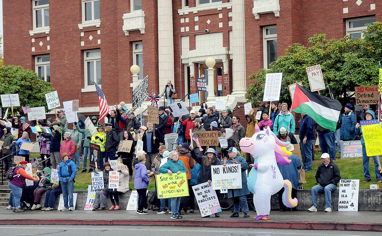 A crowd gathers on the lawn of the Clallam County Courthouse on Saturday for one of two “No Kings” rallies in Port Angeles protesting the policies of President Donald Trump and his administration. Several hundred people attended the courthouse demonstration with about a thousand at a concurrent rally at the intersection of First and Front streets on the east side of the city. (Keith Thorpe/Peninsula Daily News)