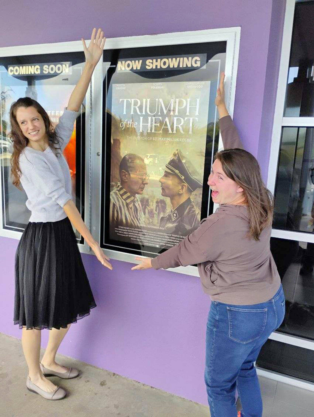 “Triumph of the Heart” producer Cecilia Stevenson, left, and her longtime friend, Amy Catterson, show off the movie poster Oct. 19 at Deer Park Cinemas.