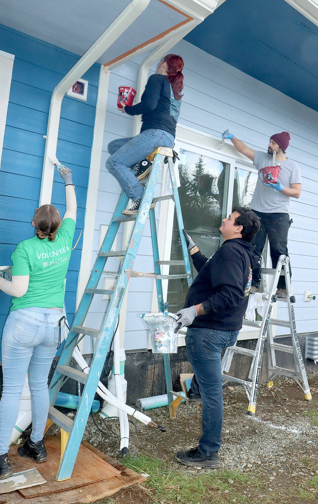 From left to right, Melissa Smith, Grace Possinger, Danny Vollin and Trevor Elder, First Fed employees at the Sixth Street branch in Port Angeles, volunteer to paint at the Habitat For Humanity Project on Wednesday at the corner of West Hazel Street and South Fairmount Avenue. About 14 bankers from two branches volunteered as part of the bank’s Community Spirit Month to paint the future home of the Ketchum Veteran Cottages. (Dave Logan/for Peninsula Daily News)