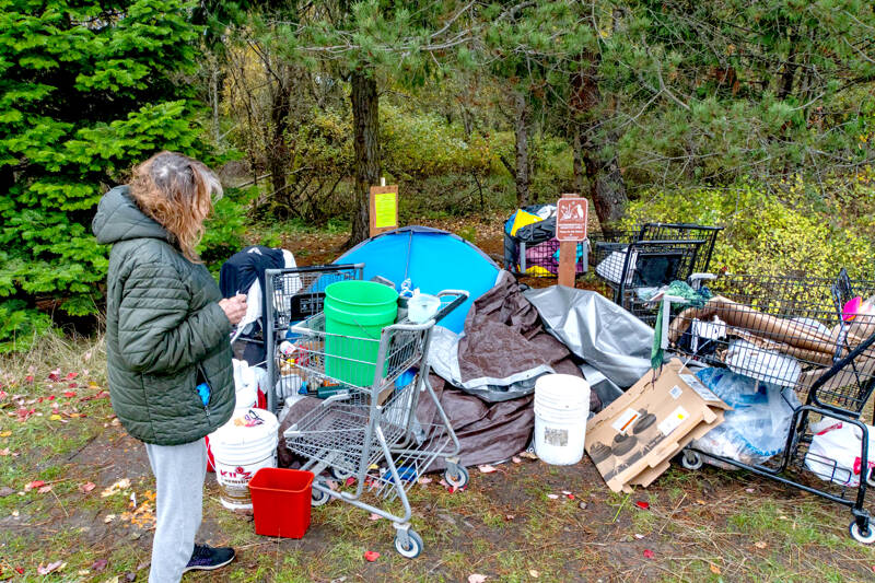 Janna Hall, 71, who said she lived at a homeless camp in Port Townsend for seven weeks, looks over her possessions that were to be moved by 5 p.m. Monday. Hall said she will be moving to an apartment in Portland today and she hopes to work part-time as a caregiver. (Steve Mullensky/for Peninsula Daily News)